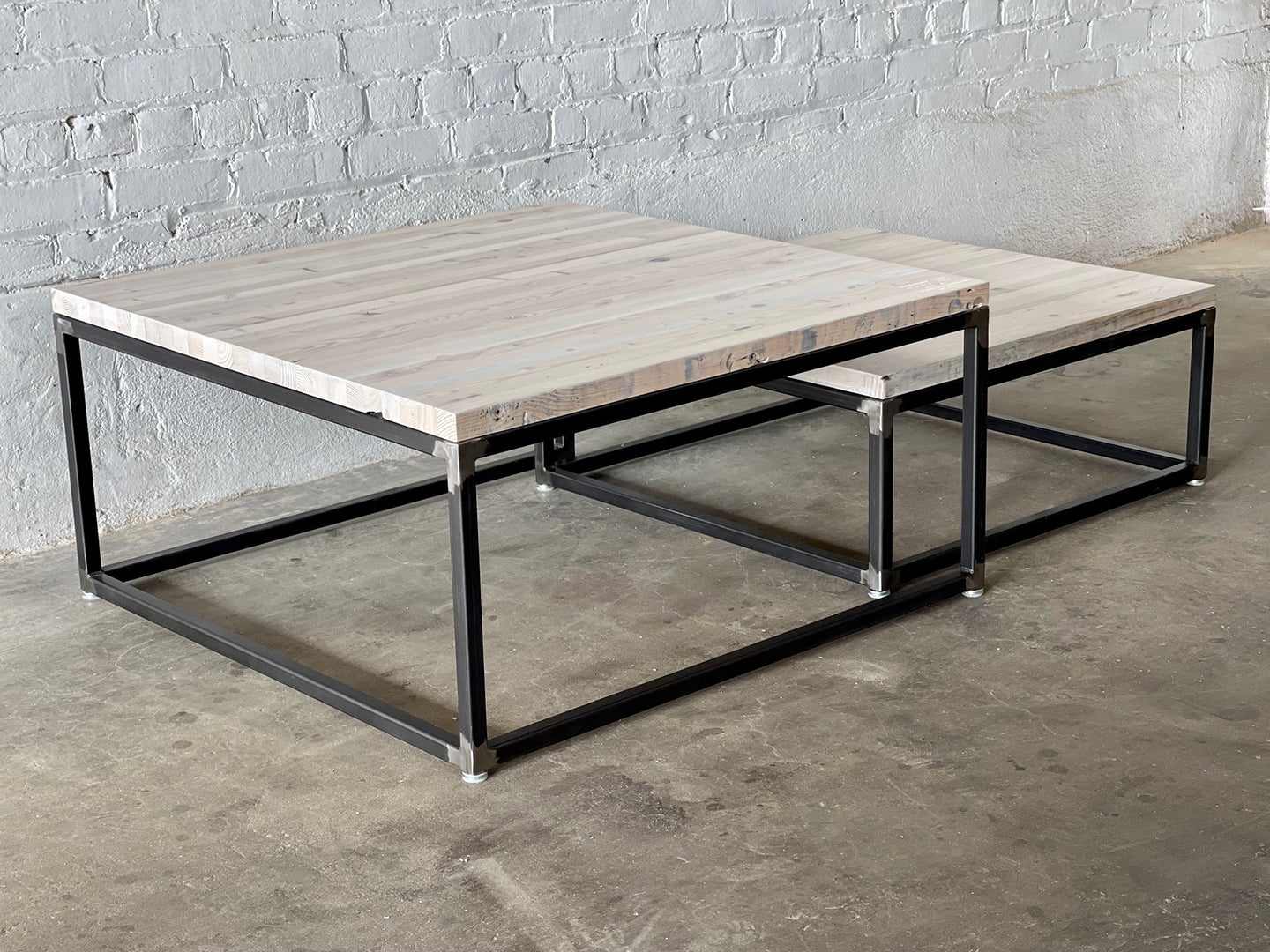 Metropolitan Nesting Coffee Table by Workshop Detroit - Shown in a coastal white finish on a concrete floor with a white brick wall in the background