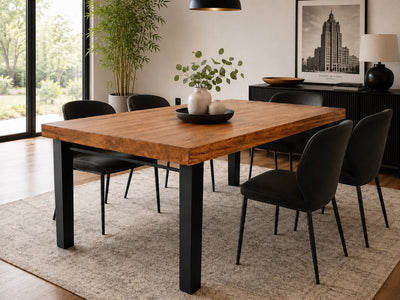 High Street Solid Reclaimed Oak Dining Table by Workshop Detroit. Shown in a contemporary dining room with black chairs, wood floors, a rug, artwork and plants.